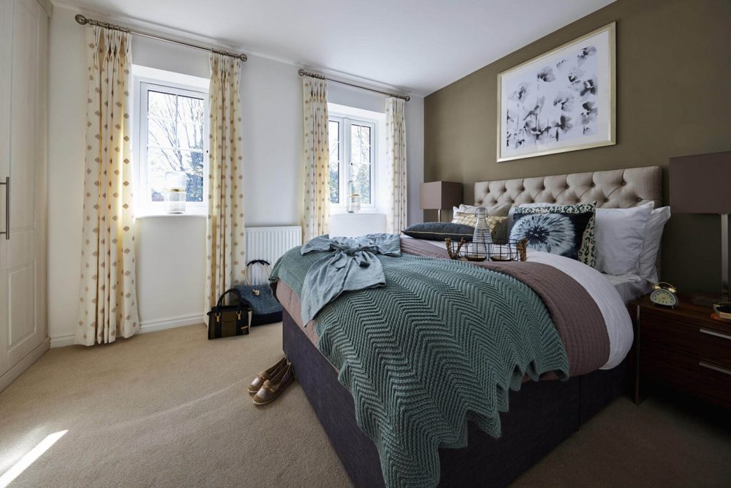 a bedroom with two windows and a bed