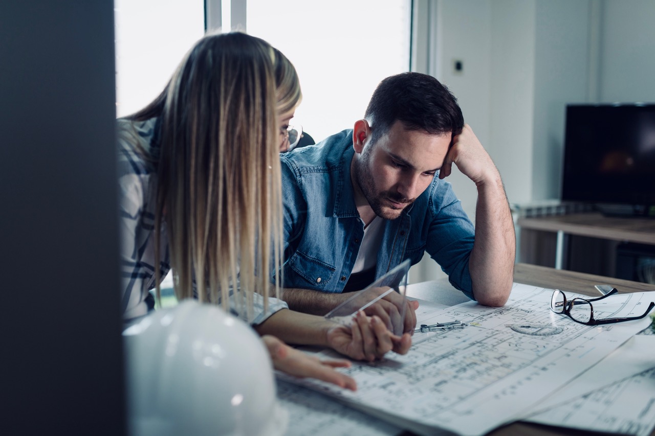 couple-looking-at- benefits of buy-to-let and architect-plans